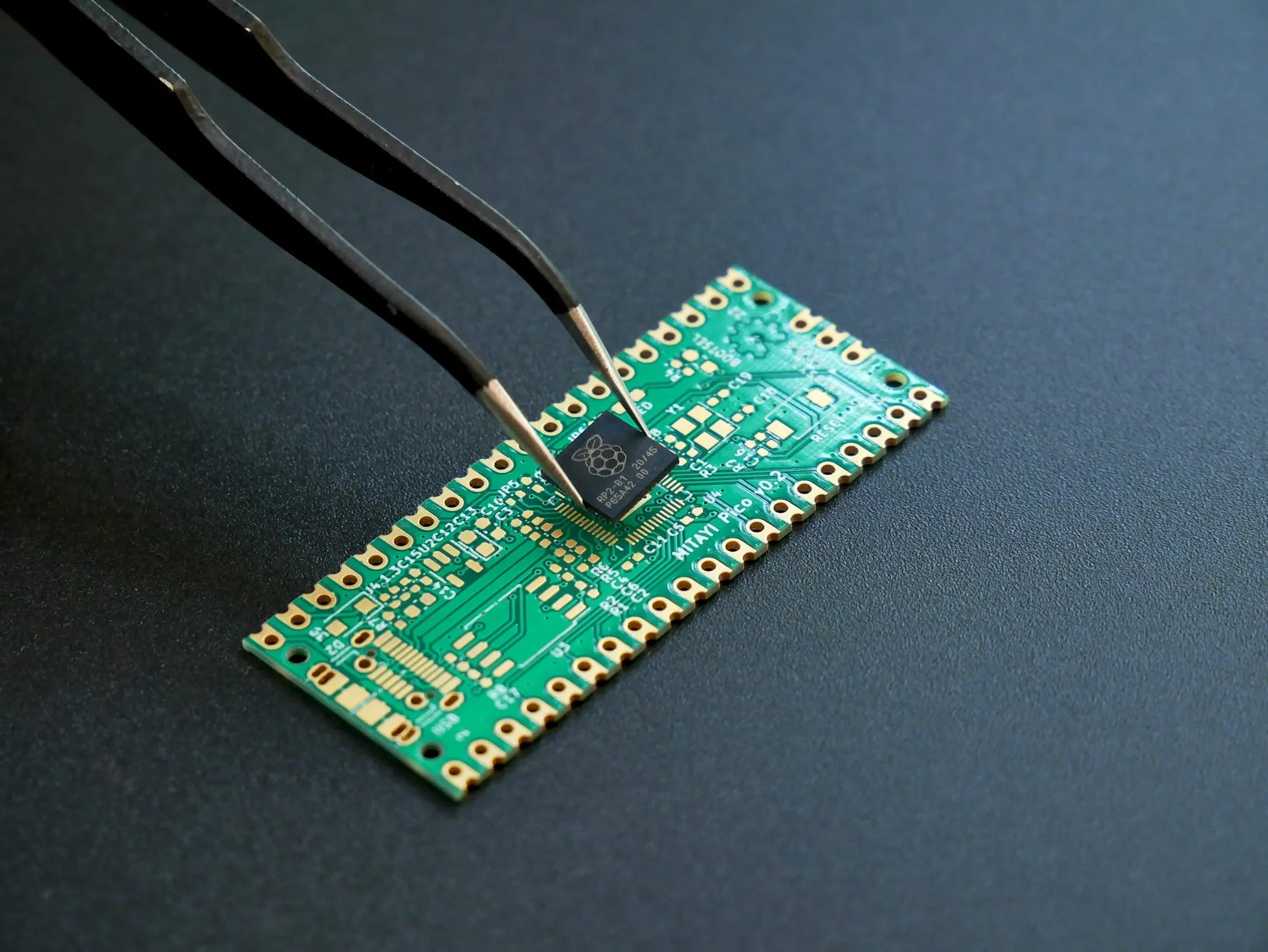 Pinzette setzt einen Chip auf eine kleine grüne Leiterplatte eines Prototyps